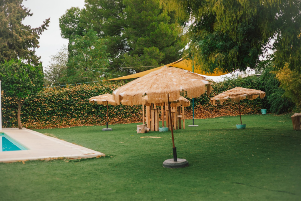Zona chill out con sombrillas junto a la piscina en Finca Buenaventura, Sevilla
