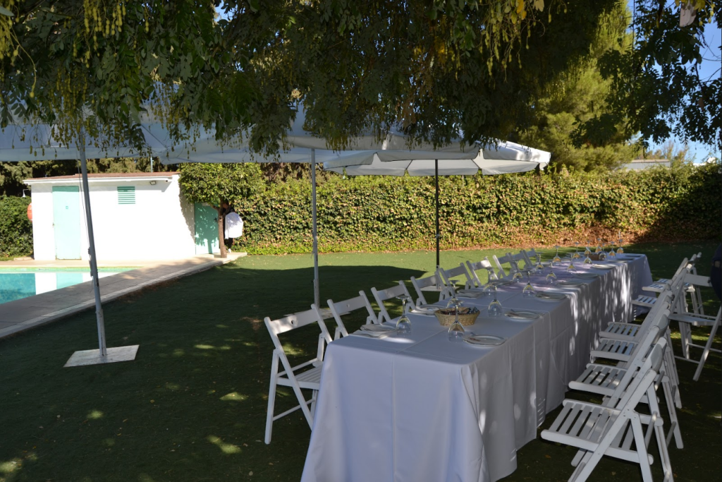 Mesa larga de banquete junto a la piscina en Finca Buenaventura, Sevilla